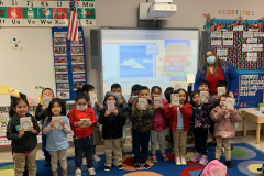 Head Start children enjoying their new books. These books go home with them so that they may build their home library.