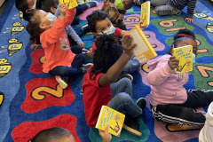 Head Start children enjoying their new books. These books go home with them so that they may build their home library.
